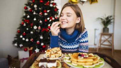 Beautiful Caucasian girl treating herself with a homemade Christmas sweets.