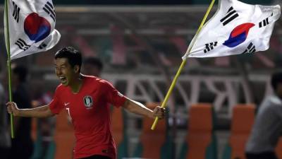 Son Heung-min celebrando con banderas de Corea del Sur al final del partido ante Japón en los Juegos Asiáticos. Foto AFP