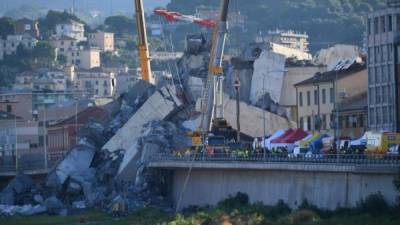 Una grúa trabaja en las labores de búsqueda de víctimas y retirada de los escombros del puente que el martes se desplomó en Génova (Italia). EFE