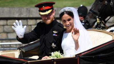 El príncipe Harry, duque de Sussex y su esposa Meghan, Duquesa de Sussex saludan desde el vagón de Ascot Landau durante su procesión de carruajes en Castle Hill, a las afueras del castillo de Windsor.