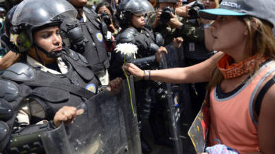 Una manifestante le obsequió una flor a un miembro de la Policía Nacional.