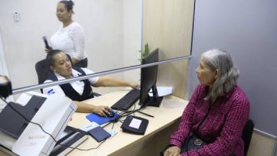 Servicio. Una usuaria en el proceso de toma de datos y huella en la ventanilla del INM. Foto: M. Cubas.