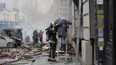 Una mujer era evacuada del edificio.