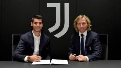 Álvaro Morata al momento de firmar con la Juventus, acompañado por Pavel Nedved, vicepresidente del equipo italiano.