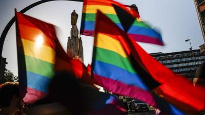 Imagen de archivo de un grupo de personas con unas banderas en el Día Internacional del Orgullo LGTBI.