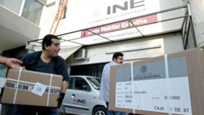 Trabajadores del Instituto Nacional Electoral (INE) descargan cajas conteniendo material electoral para las elecciones presidenciales del 1 de julio, en un depósito en Guadalajara, el 7 de junio de 2018 AFP.