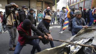 Manifestantes se enfrentan a la policía boliviana durante una protesta contra el Gobierno provisional del país ayer viernes, en el centro de La Paz (Bolivia). EFE/ Rodrigo Sura