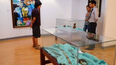El museólogo del BCH explica a unos visitantes sobre las obras de Francisco Morazán.