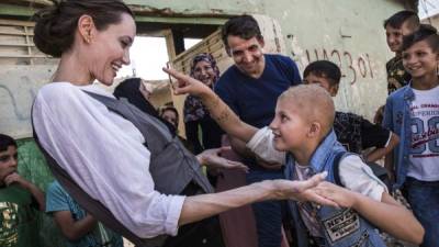 Angelina Jolie comparte con una niña refugiada. Foto AFP /Andrew McCONNELL.