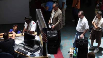 Funcionarios del servicio de Aduanas y Protección Fronteriza verifican los pasaportes de varios viajeros que llegan del extranjero al Aeropuerto Internacional de Miami. Foto Getty Images