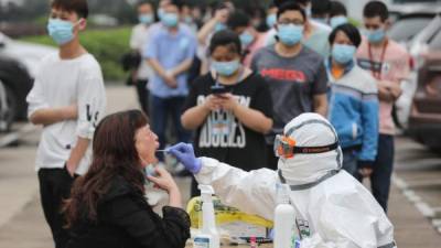 Personal médico realiza pruebas de coronavirus en Pekín. Foto: AFP
