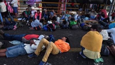 Honduran migrants heading to the United States with a second caravan rest at the border city of Ciudad Tecun Uman, Guatemala as they wait to cross to Mexico on January 19, 2019. - Hundreds of Central Americans entered Mexico illegally as the latest migrant caravan trying to reach the United States began crossing the Mexican-Guatemalan border en masse Friday (Photo by Johan ORDONEZ / AFP)