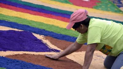 Una voluntaria trabaja en la confección de la alfombra.