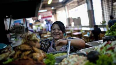 Una mujer atiende un puesto en un mercado. EFE/Saul Martinez