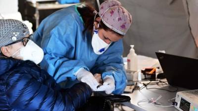 Una mujer anciana recibe asistencia en una carpa médica previa al triaje frente al hospital de Cremona, en Cremona, norte de Italia, el 4 de marzo de 2020.