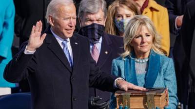 Joe Biden tomó juramento con su mano derecha levantada y la izquierda sobre una bibilia, sostenida por su esposa Jill.