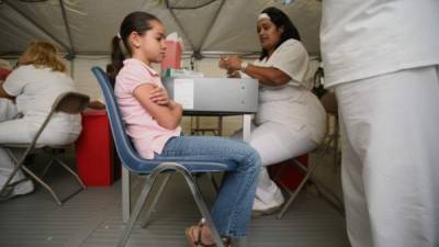 Una niña se prepara para que le pongan una vacuna contra la gripe en un hospital de San Juan, Puerto Rico. EFE/Archivo