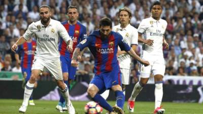 GRA378. MADRID, 23/04/2017.- El delantero argentino del FC Barcelona, Leo Messi (c), se dispone a golpear el balón ante los defensores del Real Madrid, consiguiendo el primer gol del equipo blaugrana durante el encuentro correspondiente a la jornada 33 de primera división que disputan esta tarde en el estadio Santiago Bernabéu, en Madrid. EFE / Kiko Huesca.