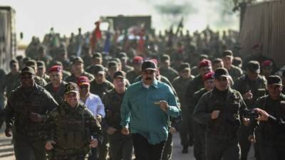 Handout picture released by the Venezuelan presidency showing Venezuela's President Nicolas Maduro (C) and Defence Minister Vladimir Padrino (2-R) running with others officials during military exercises at Fort Paramacay in Naguanagua, Carabobo State, Venezuela, on January 27, 2019. - Maduro on Sunday rejected a European ultimatum that he call elections as opposition rival Juan Guaido stepped up appeals to the military to turn against the leftist government. (Photo by Marcelo GARCIA / Venezuelan Presidency / AFP) / RESTRICTED TO EDITORIAL USE - MANDATORY CREDIT 'AFP PHOTO / VENEZUELAN PRESIDENCY / MARCELO GARCIA' - NO MARKETING NO ADVERTISING CAMPAIGNS - DISTRIBUTED AS A SERVICE TO CLIENTS