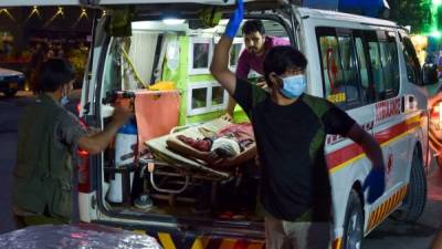 EDITORS NOTE: Graphic content / Medical staff bring an injured man to a hospital in an ambulance after two powerful explosions, which killed at least six people, outside the airport in Kabul on August 26, 2021. (Photo by Wakil KOHSAR / AFP)