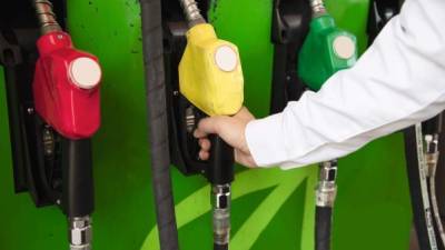 Man putting gasoline fuel into his car in a pump gas station