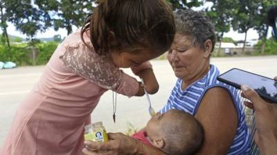 Marina da una cucharada de gerber a su prima Génesis Marisol, de cinco meses de nacida. Fotos: Moisés Valenzuela.