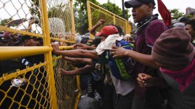 Guatemalan security forces try to prevent Honduran migrants from reaching the Guatemala-Mexico international border bridge in Ciudad Tecun Uman, Guatemala, on October 28, 2018. - A new group of Honduran migrants is trying to reach and cross the Guatemalan border into Mexico in the hope of eventually realizing the 'American dream' and reaching the United States. (Photo by SANTIAGO BILLY / AFP)