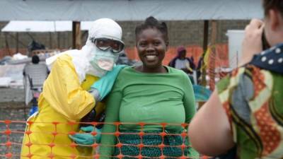 Un miembro del personal sanitario posa con una paciente recuperada de ébola en Liberia.