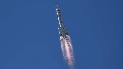 A Long March-2F carrier rocket, carrying the Shenzhou-12 spacecraft and a crew of three astronauts, heads to orbit after lifting off from the Jiuquan Satellite Launch Centre in the Gobi desert in northwest China on June 17, 2021, the first crewed mission to China's new space station. (Photo by GREG BAKER / AFP)