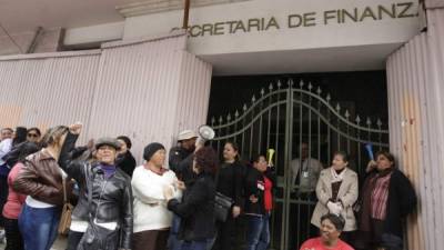 Trabajadores públicos se congregan frente a la entrada de la Secretaría de Finanzas, pidiendo ajuste salarial.