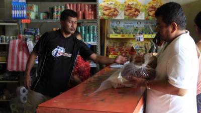 Un ciudadano aprovecha los bajos precios de la tienda para comprar una medida de frijoles. Foto: Franklin Muñoz.
