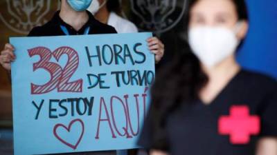 Trabajadores de la salud llevan una cruz roja como símbolo de ser recuperados de Covid-19. EFE