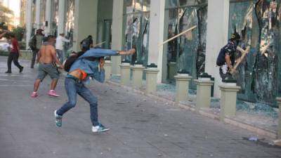 Manifestantes lanzan piedras y palos al edificio del hotel Marriot en Tegucigalpa.