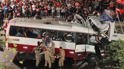 Fotografía cedida por A Crítica que muestra a un grupo de socorristas en el lugar donde un microbús y un camión tuvieron un choque frontal, un accidente que dejó al menos 14 muertos y 19 heridos en la ciudad brasileña de Manaos, capital del estado de Amazonas (Brasil). EFE