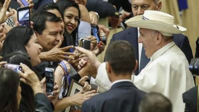 El papa Francisco (d) es obsequiado con un sombrero durante una audiencia especial para los peregrinos salvadoreños celebrada en el Aula Pablo VI del Vaticano, hoy, 15 de octubre. EFE