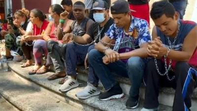 Migrantes hondureños y venezolanos se encadenaron frente al INM para exigir un permiso que les permita abandonar Chiapas.