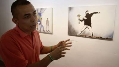 El preso Marlon Alexander Cartagena Montoya habla mientras muestra su obra 'Obstrucción' durante la inauguración de la muestra artística 'Trazos de Libertad' en el Centro Penitenciario La Paz de Itagüí (Colombia). EFE
