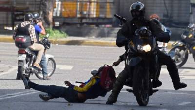 TOPSHOT - Members of the National Guard arrest an opposition activist during a demonstration against the government of Venezuelan President Nicolas Maduro, in Caracas on June 26, 2017.A political and economic crisis in the oil-producing country has spawned often violent demonstrations by protesters demanding Maduro's resignation and new elections. The unrest has left 75 people dead since April 1. / AFP PHOTO / Juan BARRETO