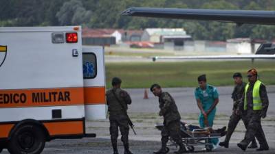 Guatemalan Army members carry a mand on a stretcher who was wounded in El Estor municipality, Izabal department, upon his arrival at the Air Force Base in Guatemala City on September 05, 2019. - A group of alleged drug traffickers executed three soldiers in northern Guatemala after an ambush on Tuesday in which three other military men were wounded and two went missing, government sources reported. (Photo by Johan ORDONEZ / AFP)