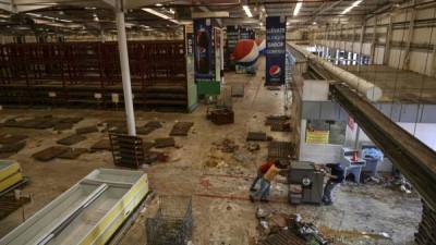 TOPSHOT - General view inside a wholesale supermarkert looted during the massive blackout that has paralyzed Venezuela for six days, in Maracaibo, in the border state of Zulia on March 13, 2019. - More than 500 shops were plundered in the oil tanker Zulia state (northwest). Although Caracas and the states of Miranda and Vargas -- home to the country's international airport and main port -- had intermittent power, the western states of Barinas, Tachira and Zulia remained without electricity. (Photo by JUAN BARRETO / AFP)
