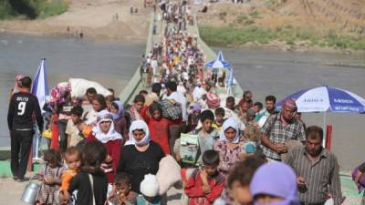 Miles de yazidíes que lograron escapar del monte Sinjar, cruzan la frontera de Siria, huyendo del Estado Islámico.
