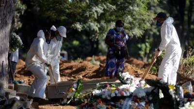 Empleados cargan un ataúd de una persona supuestamente de COVID-19 durante su funeral este miércoles en el cementerio de Vila Formosa en Sao Paulo (Brasil). EFE/Fernando Bizerra Jr