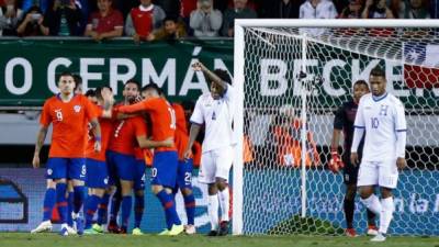 Chile's Alexis Sanchez (C at left, face covered) celebrates with teammates after scoring the team's third goal against Honduras during a friendly football match at the German Becker stadium, in Temuco, Chile, on November 20, 2018. (Photo by Pablo VERA / AFP)