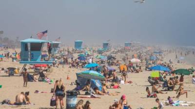 (FILES) In this file photo taken on April 25, 2020 people enjoy the beach amid the novel coronavirus pandemic in Huntington Beach, California. - California Governor Gavin Newsom will order all beaches closed on May 1, US media reported on April 29, 2020, after tens of thousands of Californians flocked to beaches last weekend, amid the coronavirus pandemic. (Photo by Apu GOMES / AFP)