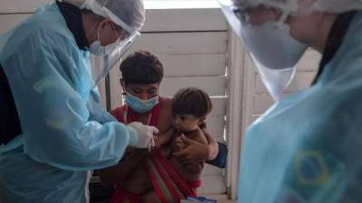 EDITORS NOTE: Graphic content / Members of the Brazilian Armed Forces medical team take a blood sample from a baby of the Yanomami ethnic group to make a COVID-19 test at a Special Border Platoon, where tests for COVID-19 are being carried out, in the indigenous land of Surucucu, in Alto Alegre, Roraima state, Brazil, on July 1, 2020. (Photo by NELSON ALMEIDA / AFP)