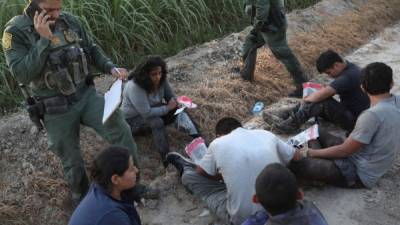 Agentes de la patrulla fronteriza retienen a varios inmigrantes. AFP