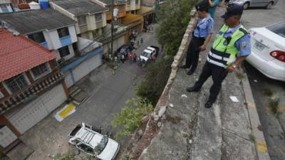 Elementos de la Policía observan la tragedia desde la altura del estacionamiento de donde cayó el carro.