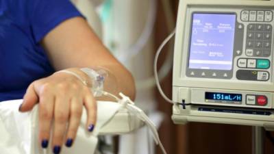 Infusion pump feeding IV drip into patients arm focus on needle