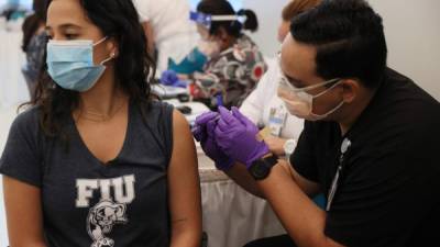 La universitaria Camila Gutierrez recibe la primera dosis de la vacuna de Pfizer en Miami./AFP.