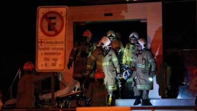 Bomberos trasladan a un paciente rescatado del incendio del Hospital Badim.